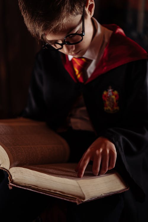 Free A Boy in a Harry Potter Costume Reading a Book Stock Photo