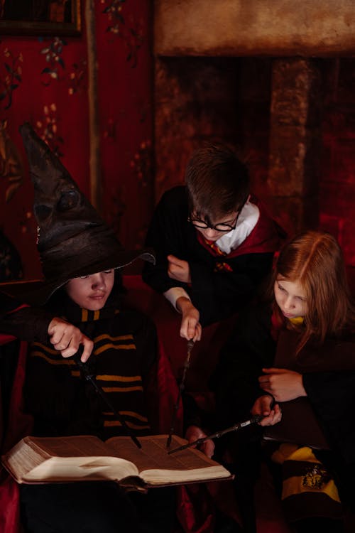 Children in Wizard Costumes with Magic Wands and Spellbook