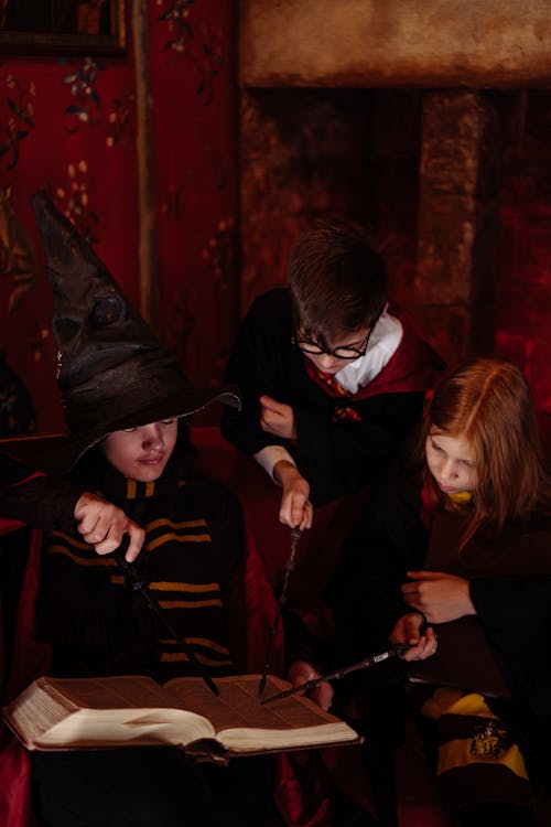 Children in Wizard Costumes with Magic Wands and Spellbook