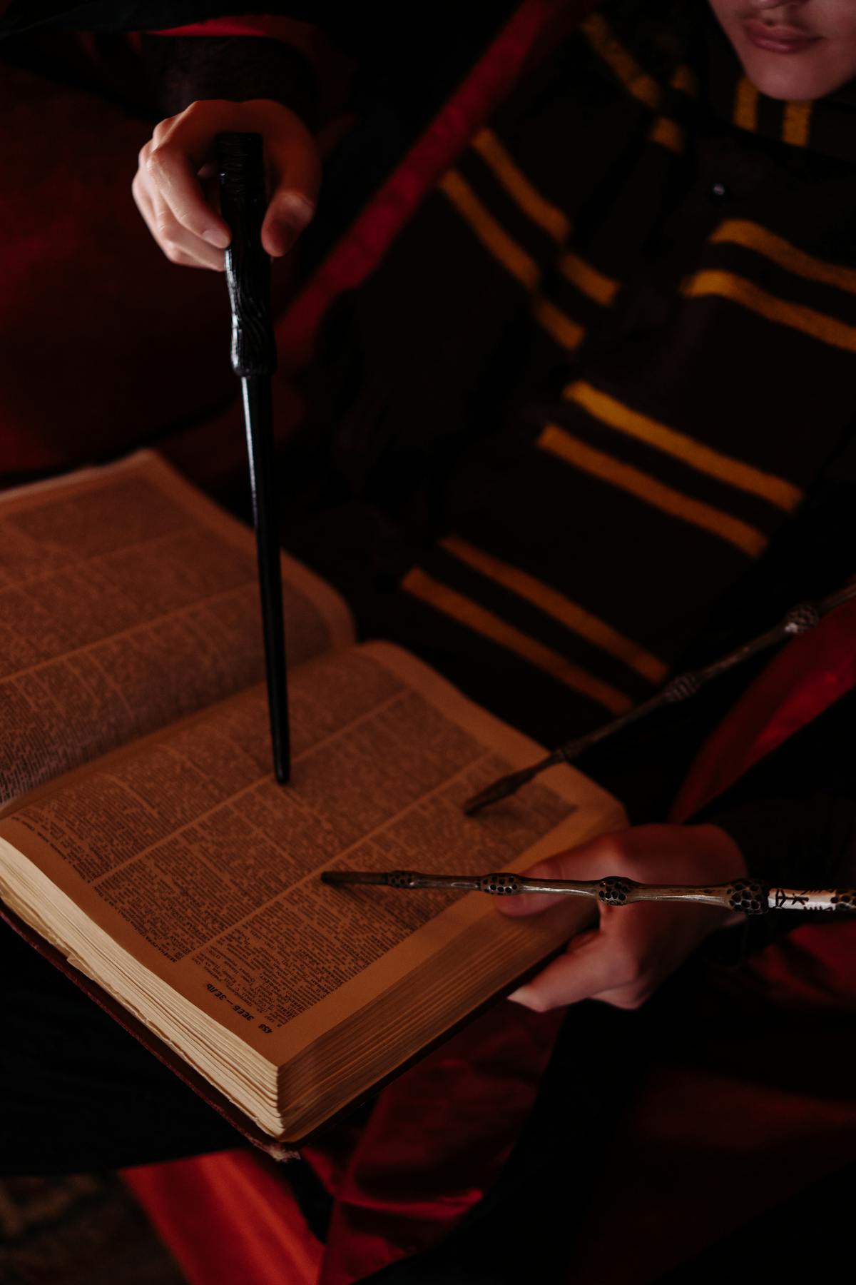 Bacchetta puntata su un libro aperto illuminato da luce soffusa