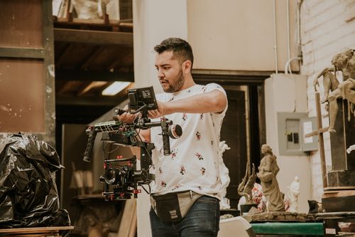 Free A filmmaker uses high-end camera equipment in a studio setting, capturing cinematic scenes. Stock Photo