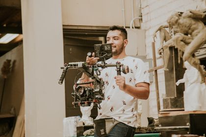 Camera operator with a rigged cinema camera in a workshop — photo by Amar Preciado on Pexels