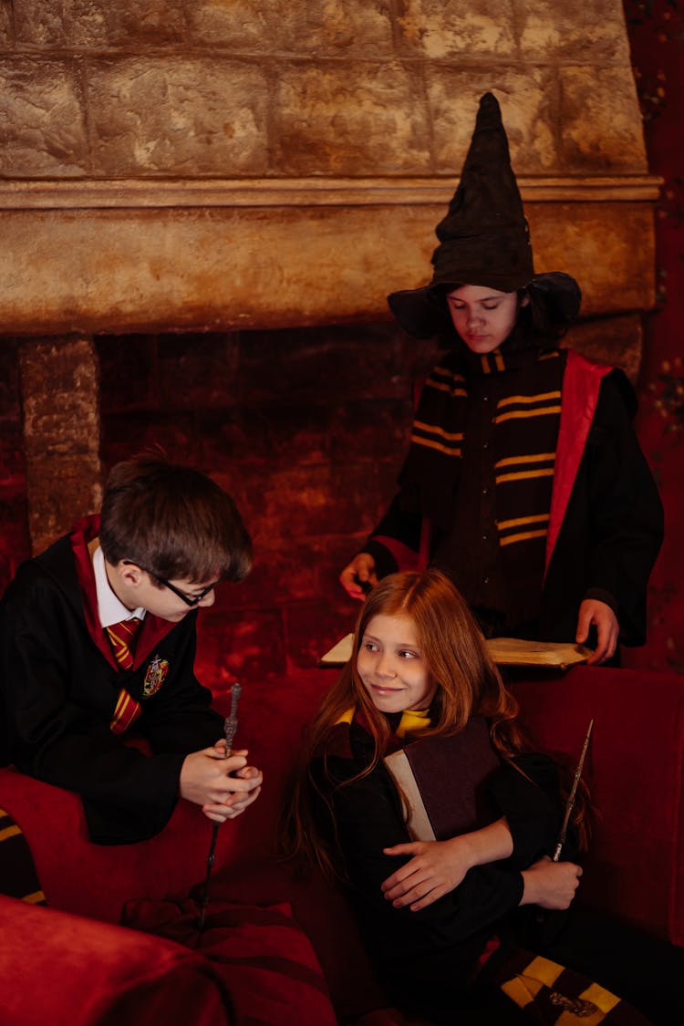 Students Sitting In A Harry Potter Black Robes Holding A Magic Wands And Spell Book