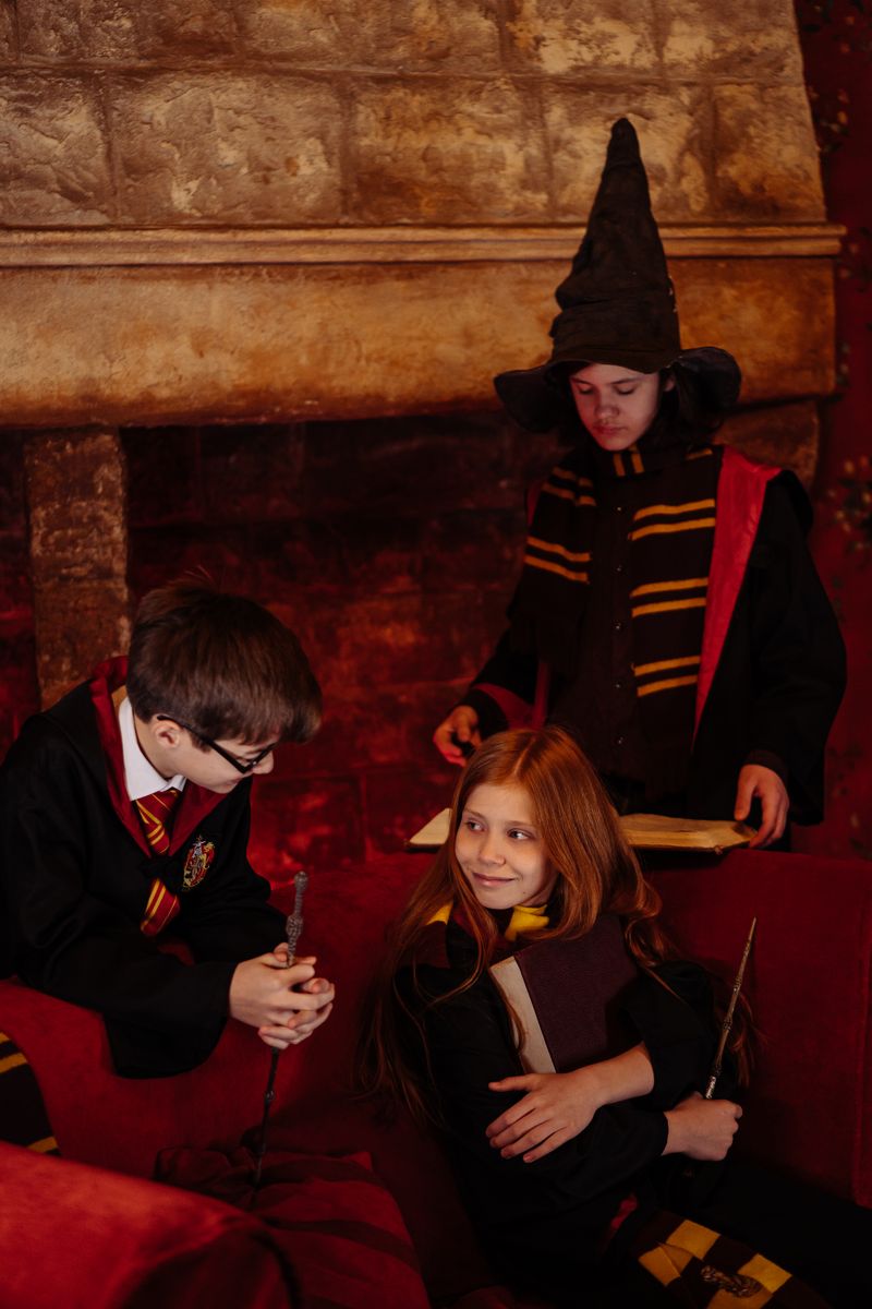 Students dressed as young wizards with magic wands and a spell book