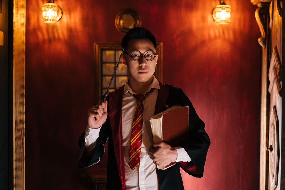 ファンタジーをテーマにした魔法使いの衣装を着た男性のポートレート、杖と本を持っています。
