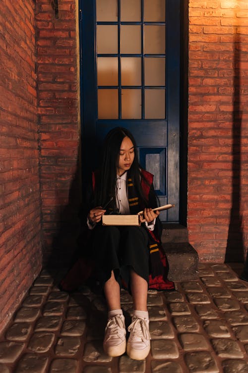 Woman Sitting on Door Step Reading Book