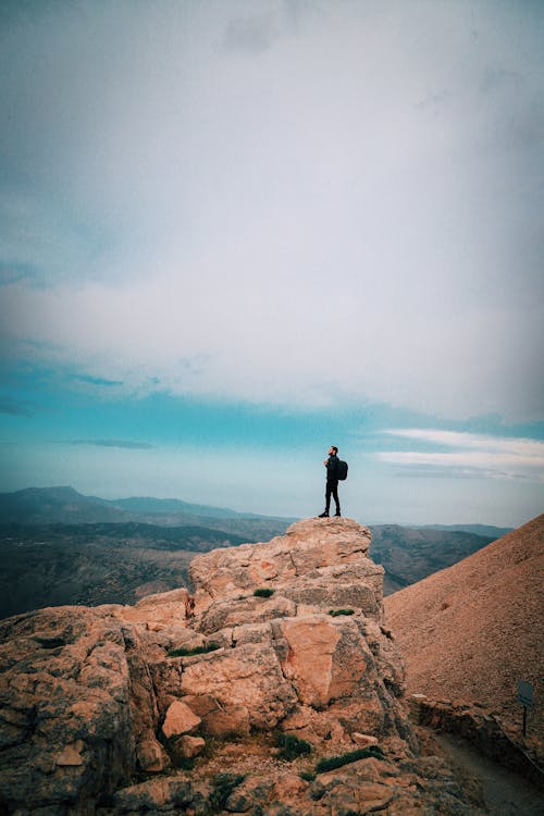 Person Standing on Big Rock Formation · Free Stock Photo
