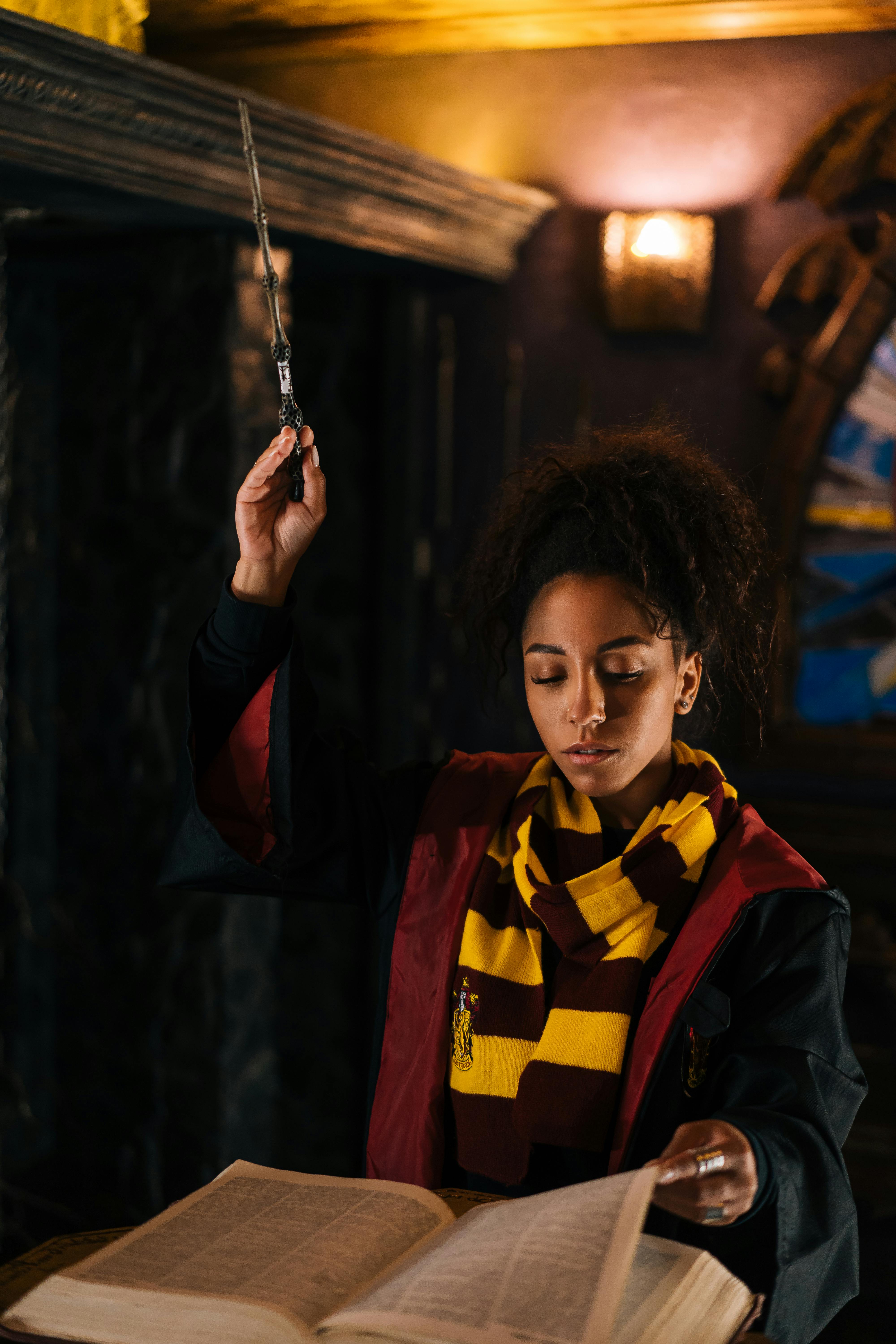 a young woman holding a magic wand while reading a book