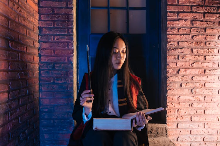 Woman Holding A Book And Wand