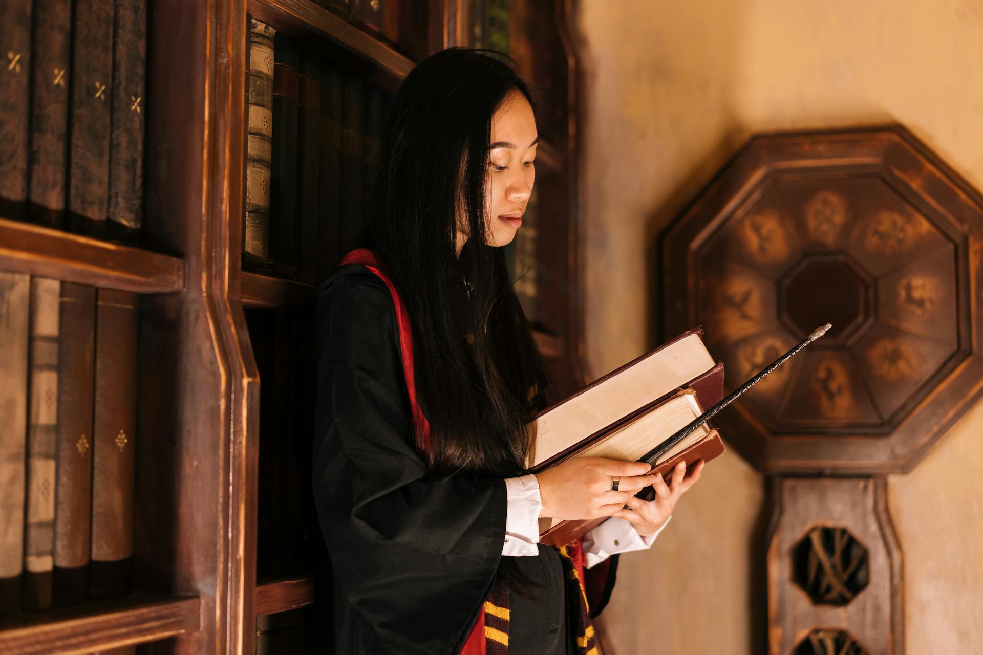 Woman Leaning on Shelves Holding Books and Wand