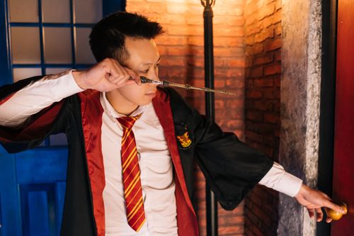 Free A young adult dressed as a wizard practicing magic indoors, capturing a magical fantasy theme. Stock Photo