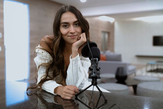 Creator recording a podcast episode at a microphone — photo by Los Muertos Crew on Pexels