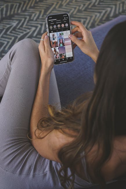 An adult woman browsing social media on a smartphone indoors.