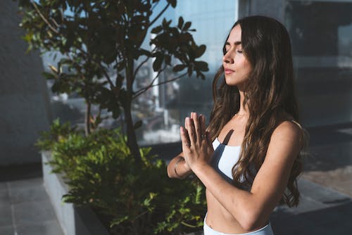 Free A Woman Meditating with Her Eyes Closed Stock Photo