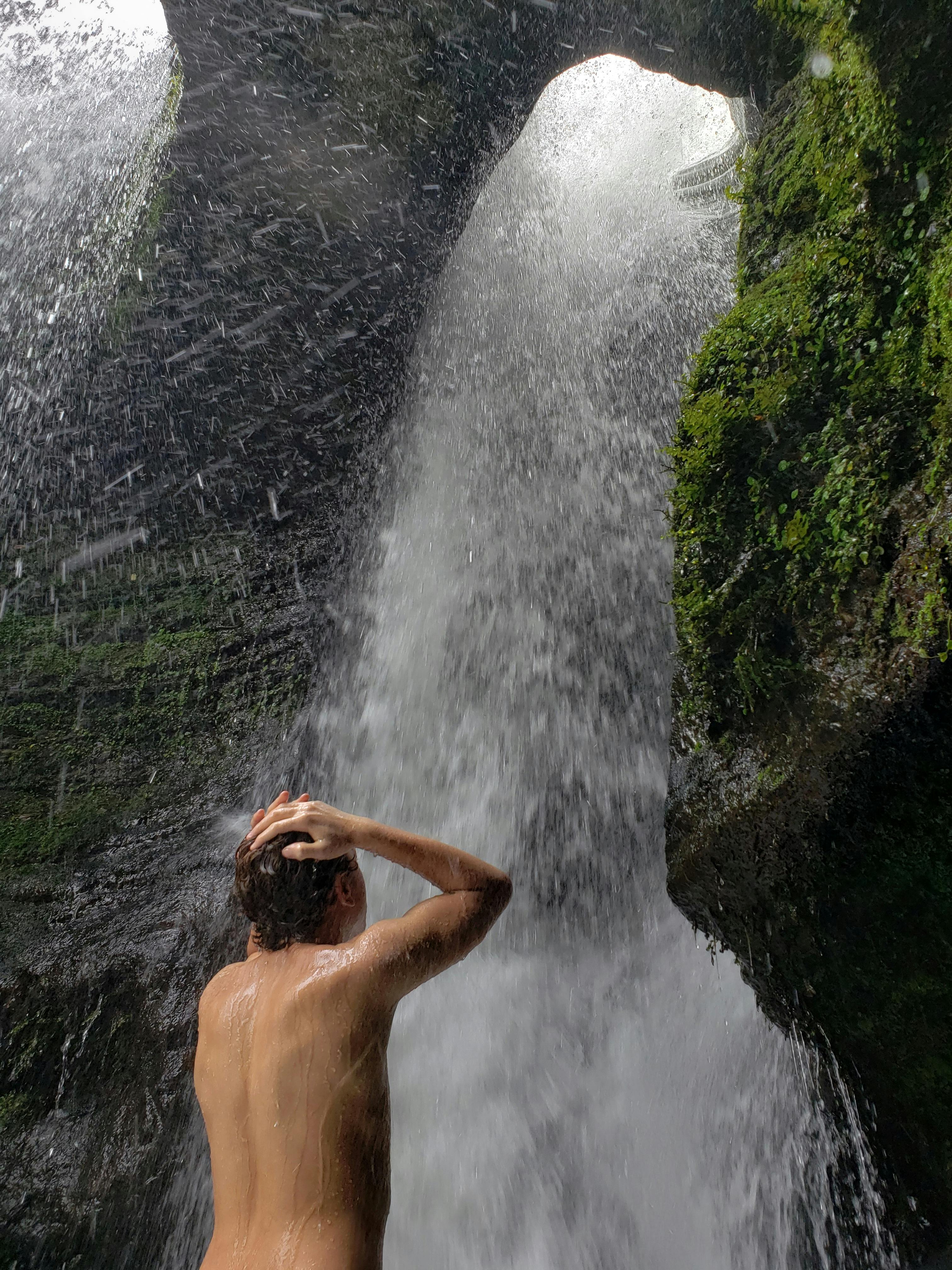 Man Showering Under Waterfalls · Free Stock Photo