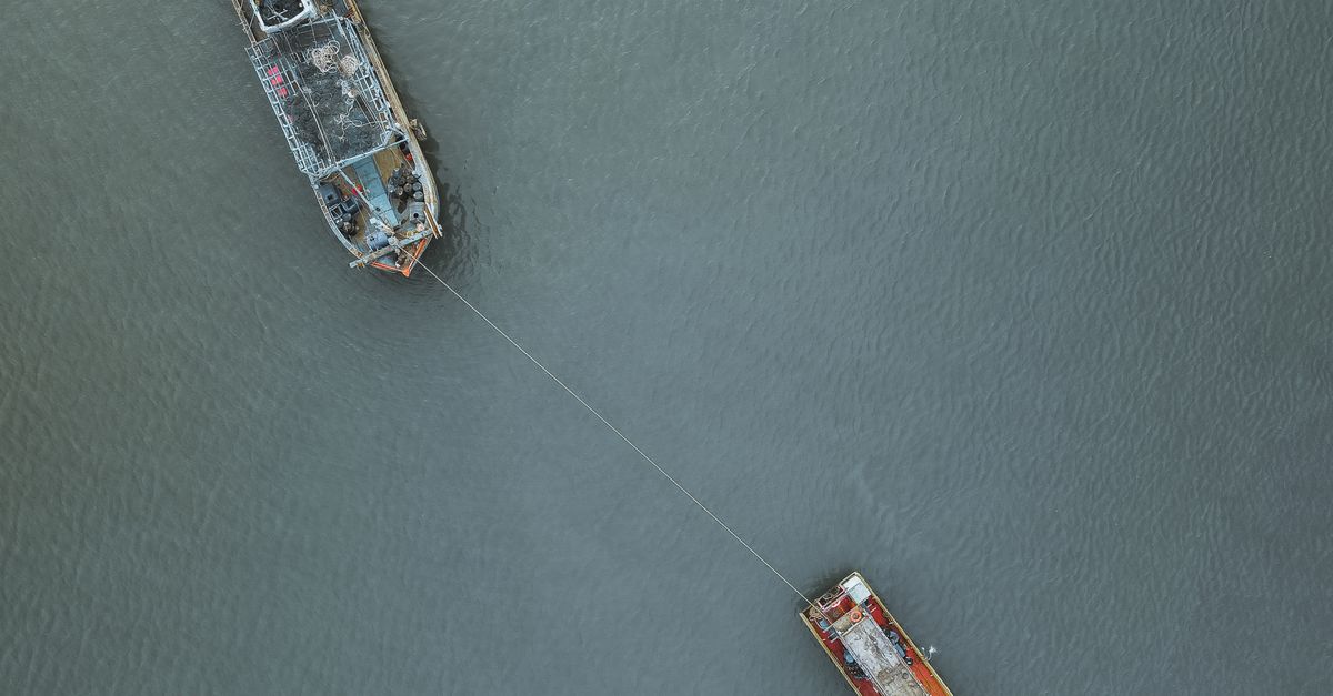 Aerial photograph of a tugboat towing a ship off the coast of Chukai, Malaysia.