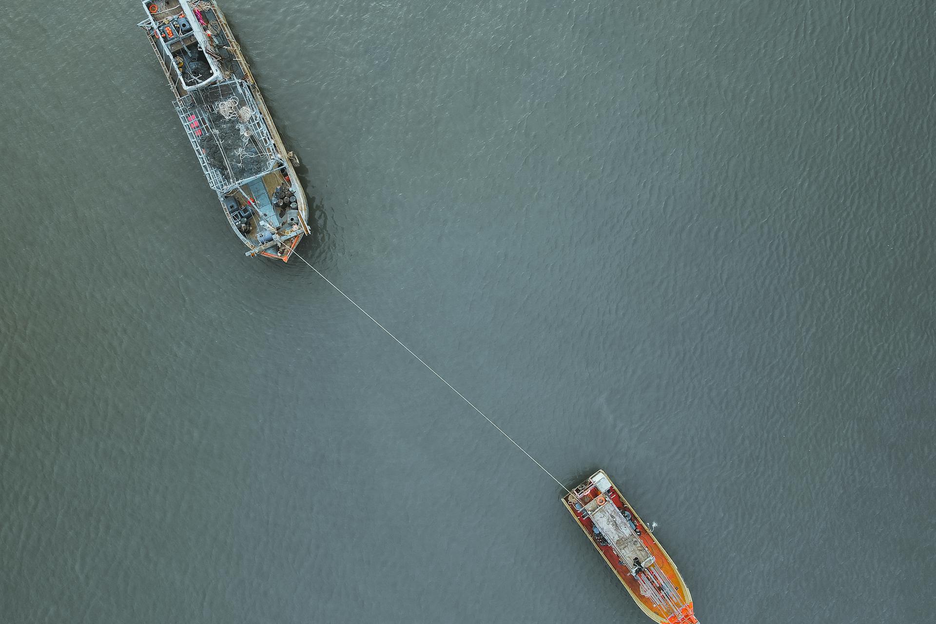 Aerial photograph of a tugboat towing a ship off the coast of Chukai, Malaysia.