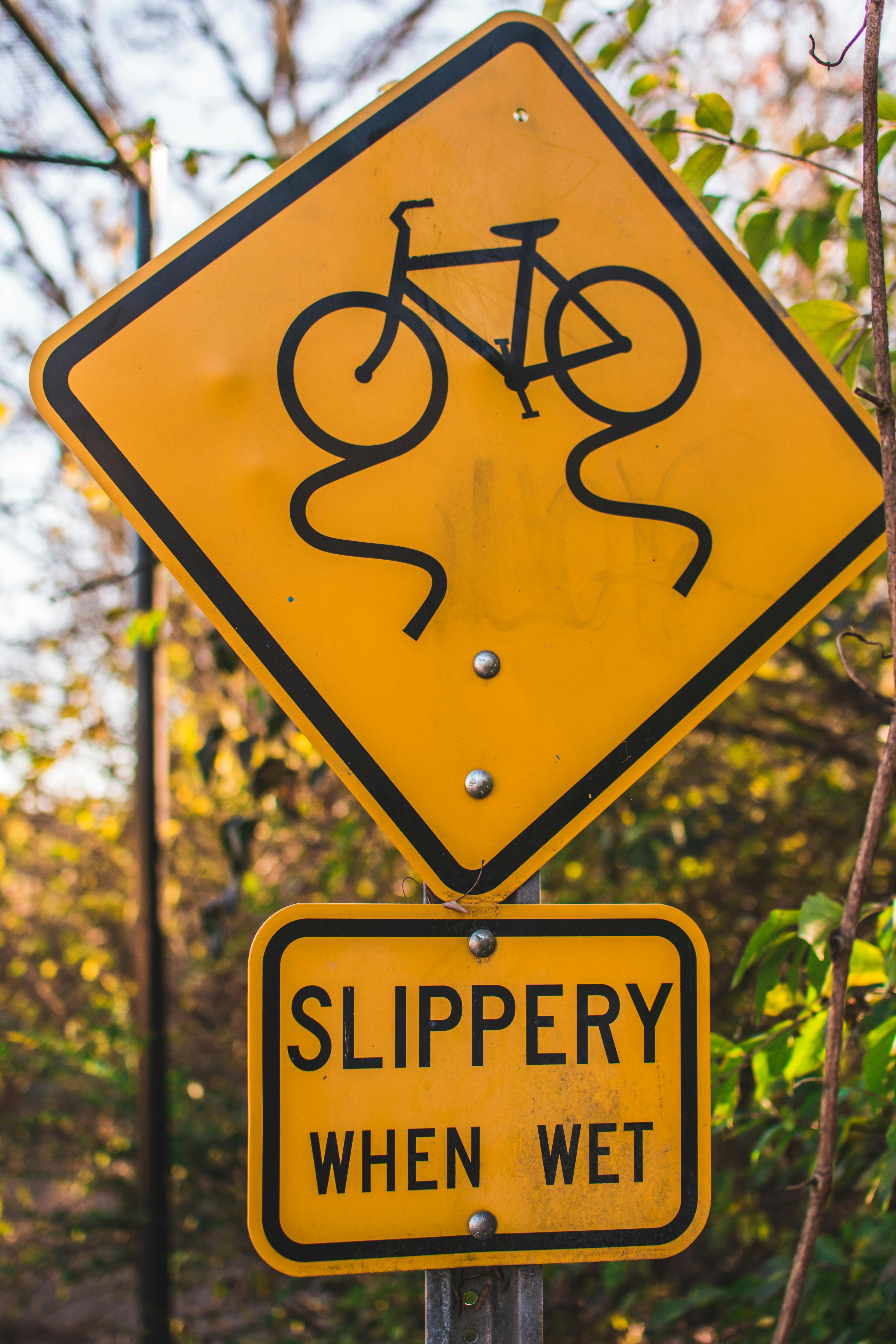 Yellow and Black Slippery When Wet Road Sign Board · Free Stock Photo