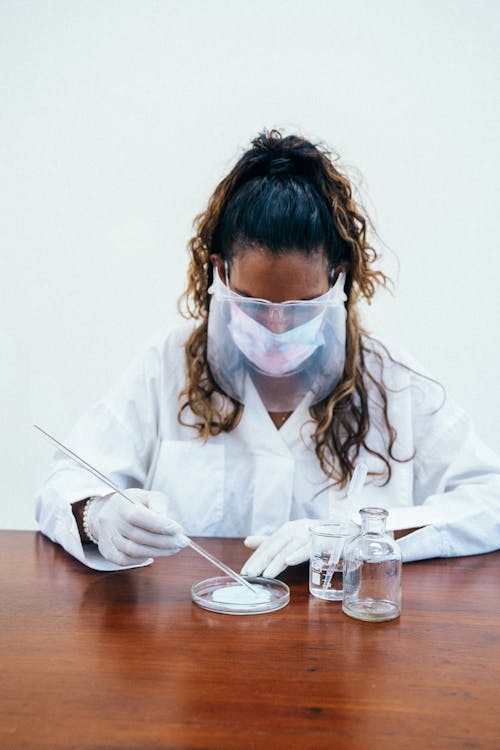 Woman Wearing Face Mask and Face Shield While Experimenting 