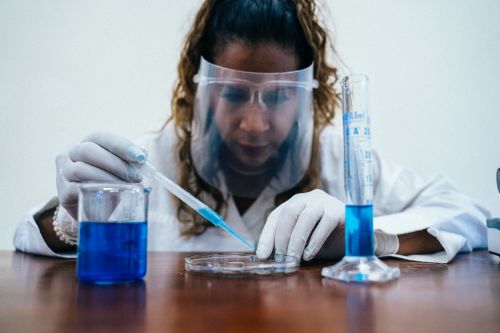Free Scientist uses droppers and glassware in a lab for experiments. Stock Photo