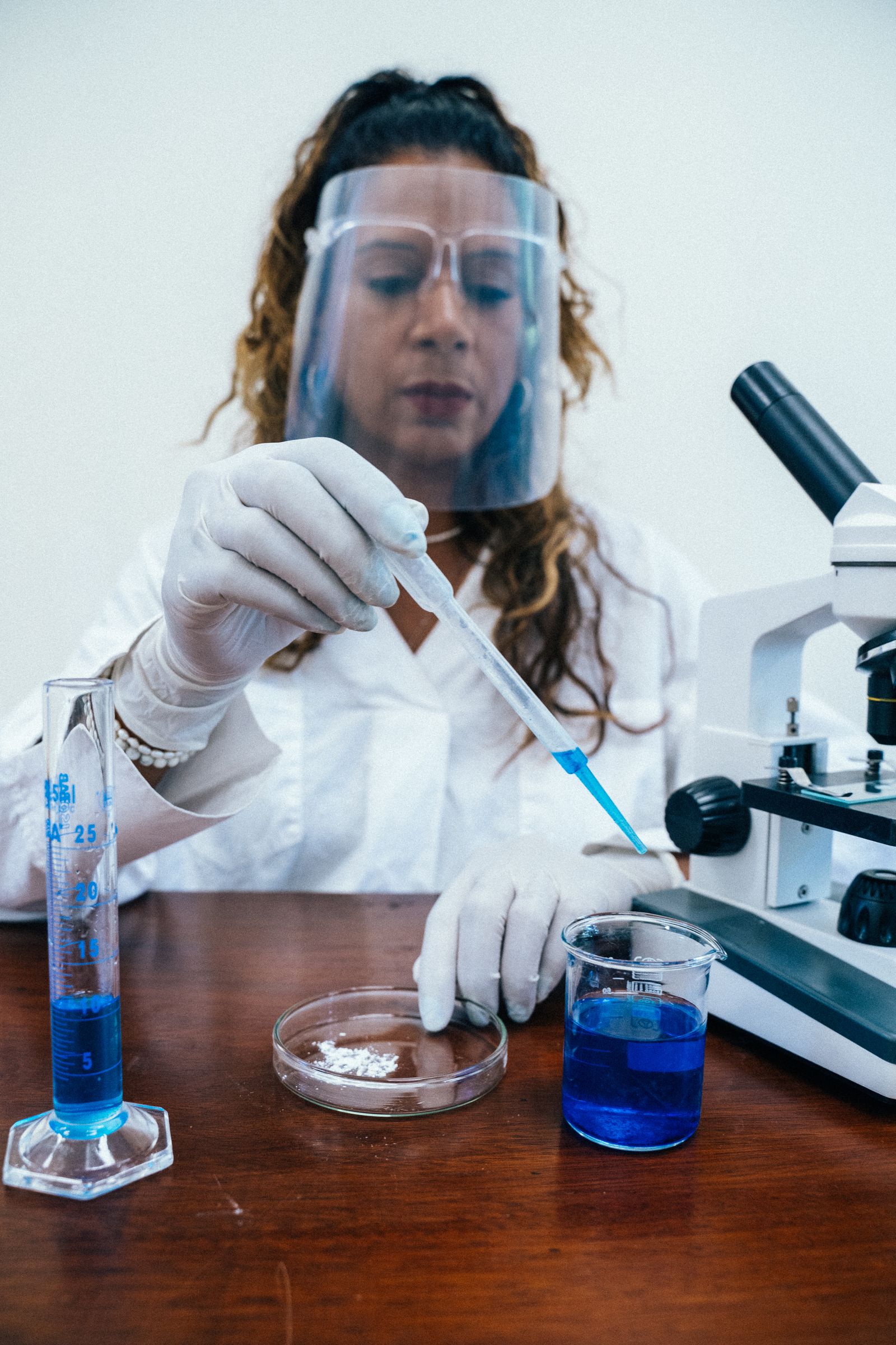 Specialista prepara campioni con pipetta accanto al microscopio