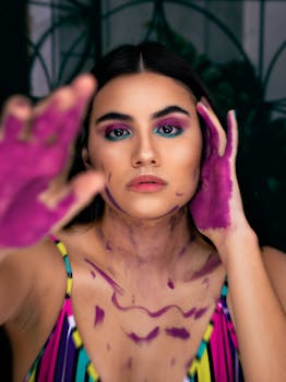 Expressive portrait of a woman with vibrant makeup and painted hands.