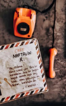 Vintage orange phone with text from Cafe Naftalin on a postcard.