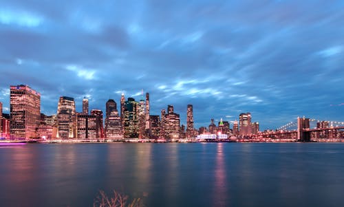 City Skyline Across Body of Water during Night Time