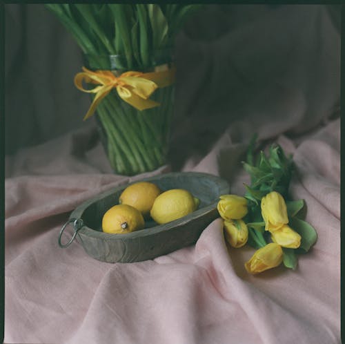 Yellow Tulips Beside Lemons in a Tray