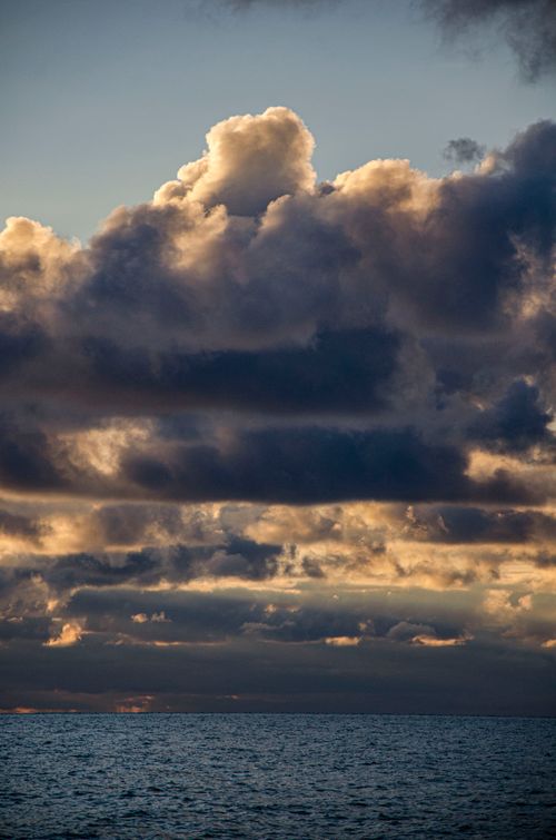 Free Stunning view of dramatic clouds over the ocean during sunset, capturing nature's beauty. Stock Photo