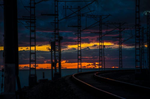 Beautiful Sunset Over a Sea and Next to Silhouetted Railway 