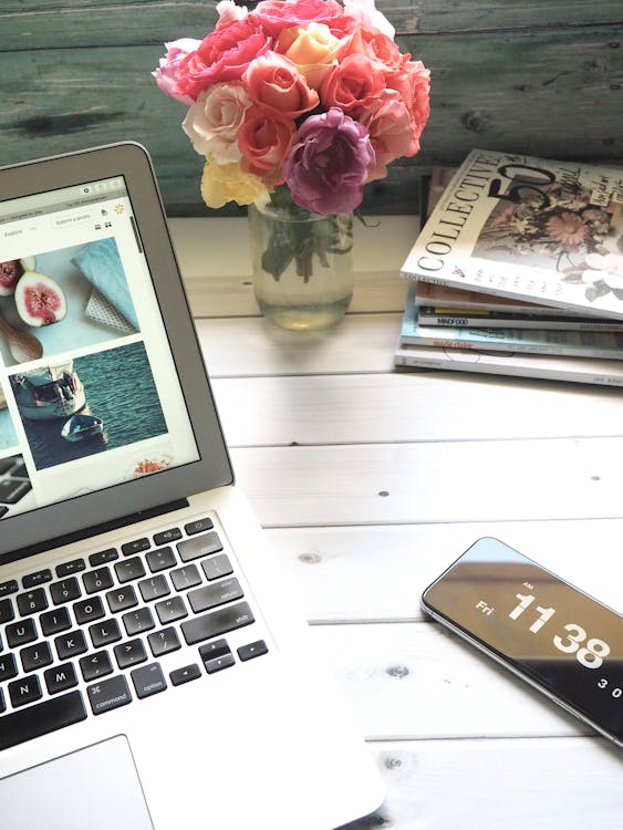 Macbook Air, Buquê De Flores E Revistas Na Mesa Branca