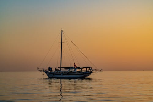 Darmowe zdjęcie z galerii z kolory zachodu słońca, łódź, morze