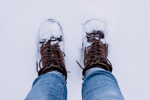 Close-up of boots in snow, capturing winter fashion and seasonal feel.