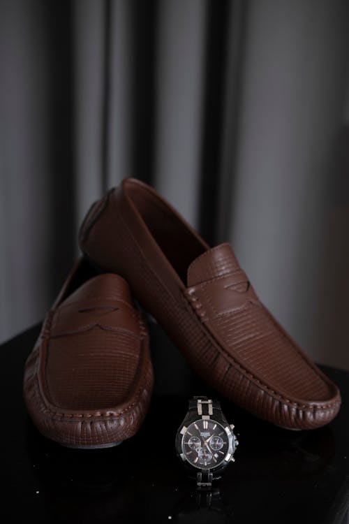 Free Brown Leather Slip on Shoes near Wristwatch Stock Photo