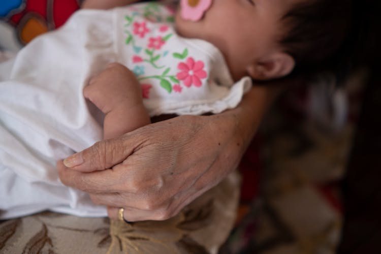 Person Carrying A Sleeping Baby