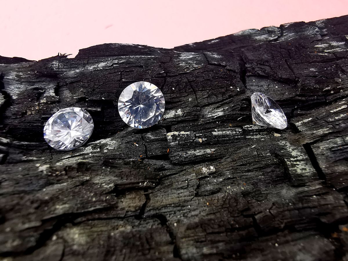 Diamantes brutos sobre superfície escura