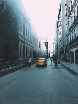 A bustling street in Beyoğlu, Istanbul featuring a yellow taxi and pedestrians.
