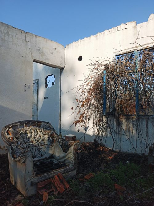 Free An abandoned house with a broken chair and overgrown vegetation in Fethiye, Türkiye. Stock Photo