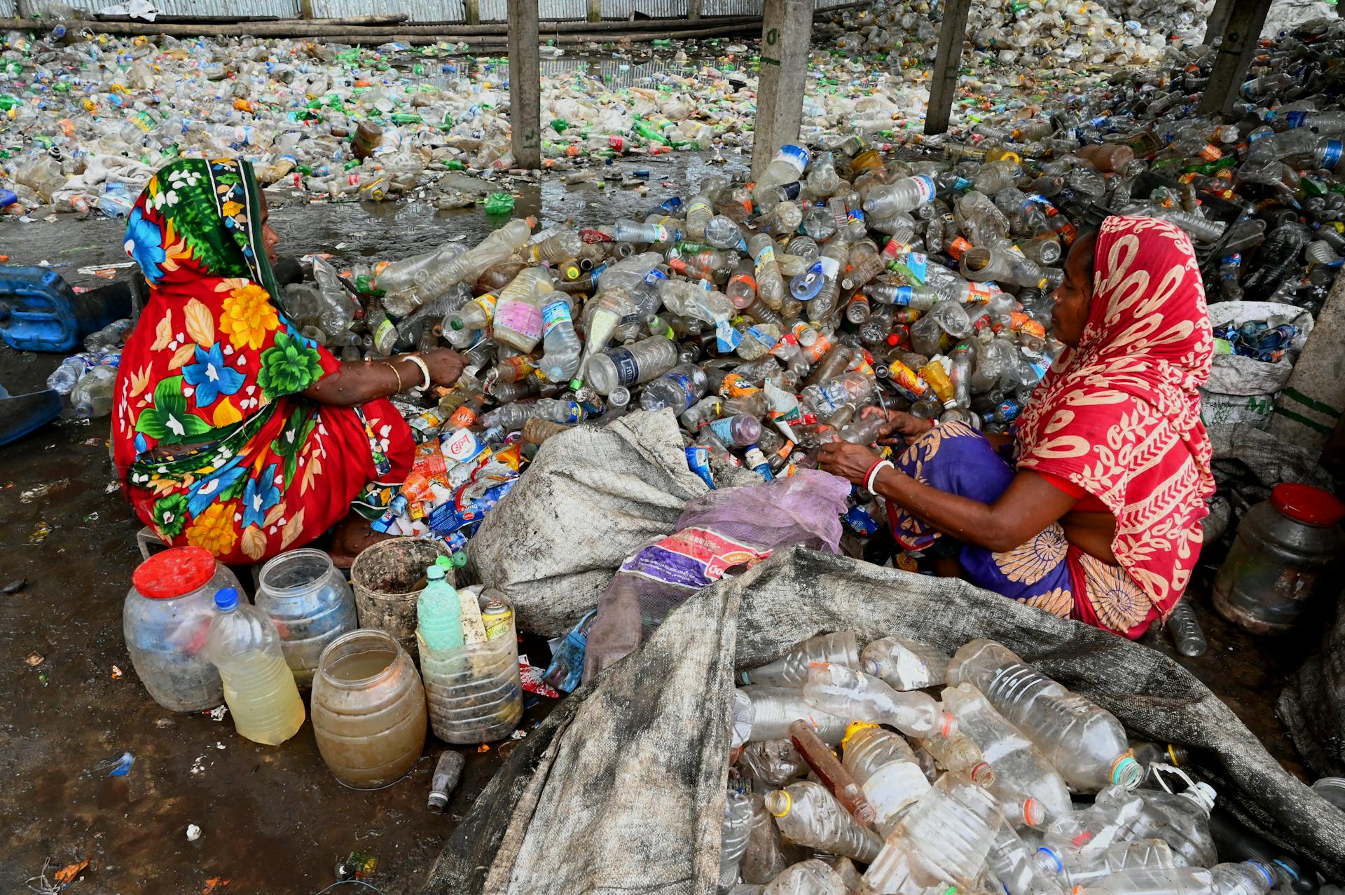 Woman Sitting on Recycled Trash of Plastic Bottles