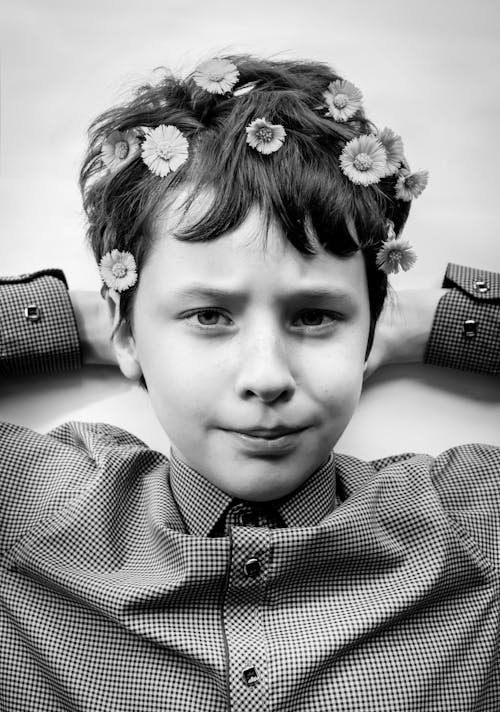 Black and White Photo of a Boy with Flowers on Hair