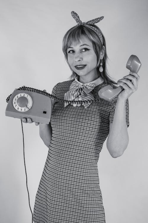 Free Grayscale Photo of a Woman Holding a Telephone Stock Photo