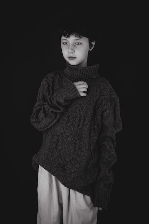 Boy in Black Sweater Standing near Black Wall