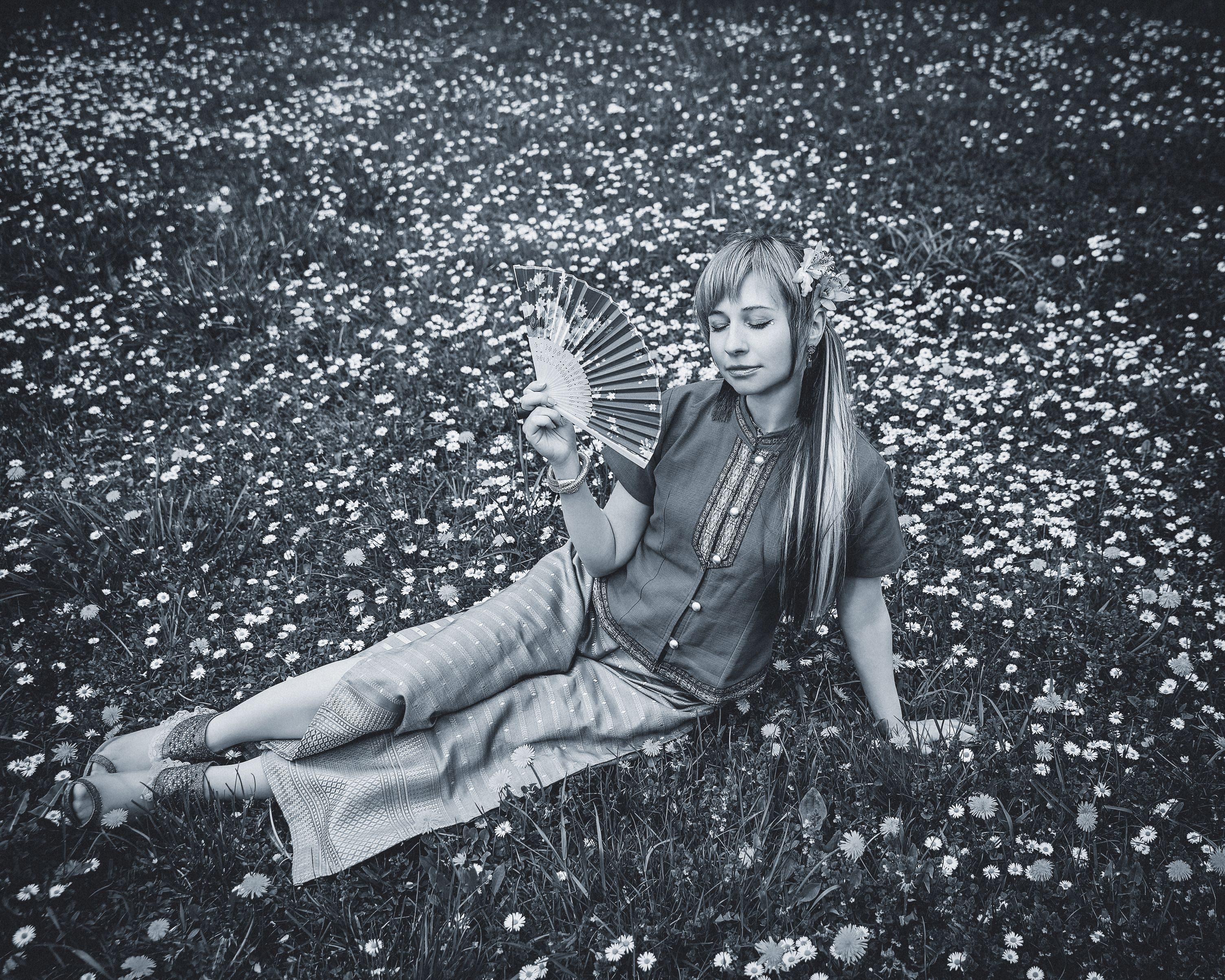 Grayscale Photo of a Woman Sitting on Grass Field · Free Stock Photo