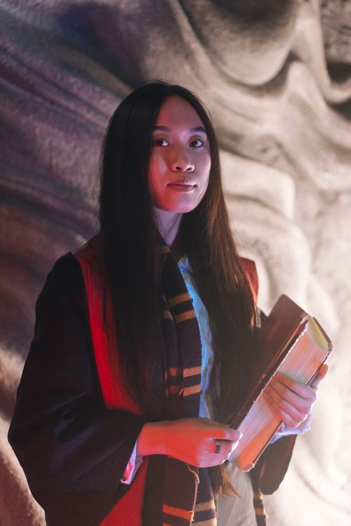 Free Woman dressed as wizard holding a book, embodying magical fantasy themes. Stock Photo
