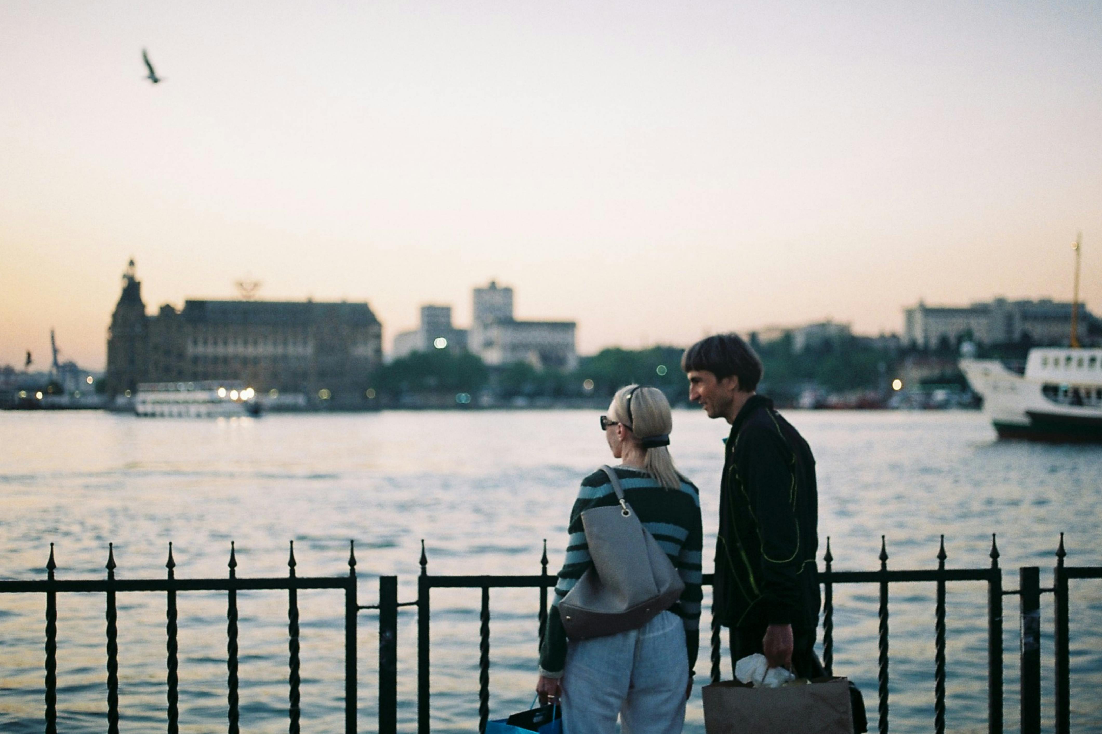 A couple enjoys a serene evening view by the Bosphorus in Istanbul, Turkey.