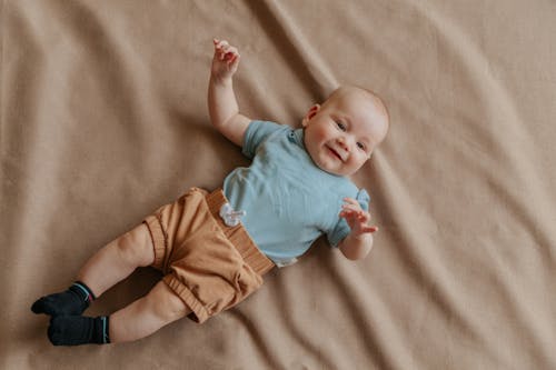 Cute Baby Lying Down on Brown Fabric