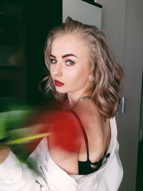 Free Elegant portrait of a young woman with blonde hair and red lipstick in an indoor setting. Stock Photo