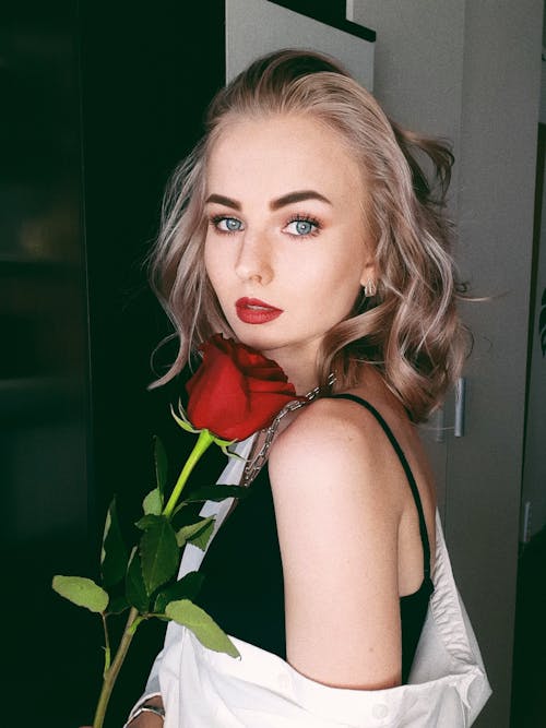 A Woman in Red Lipstick Holding a Red Rose