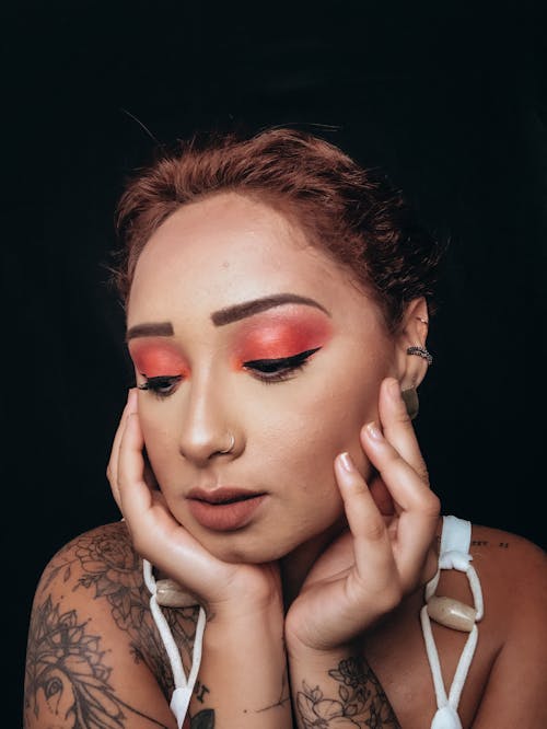 A Woman with Eye Makeup with Her Hands on Her Face